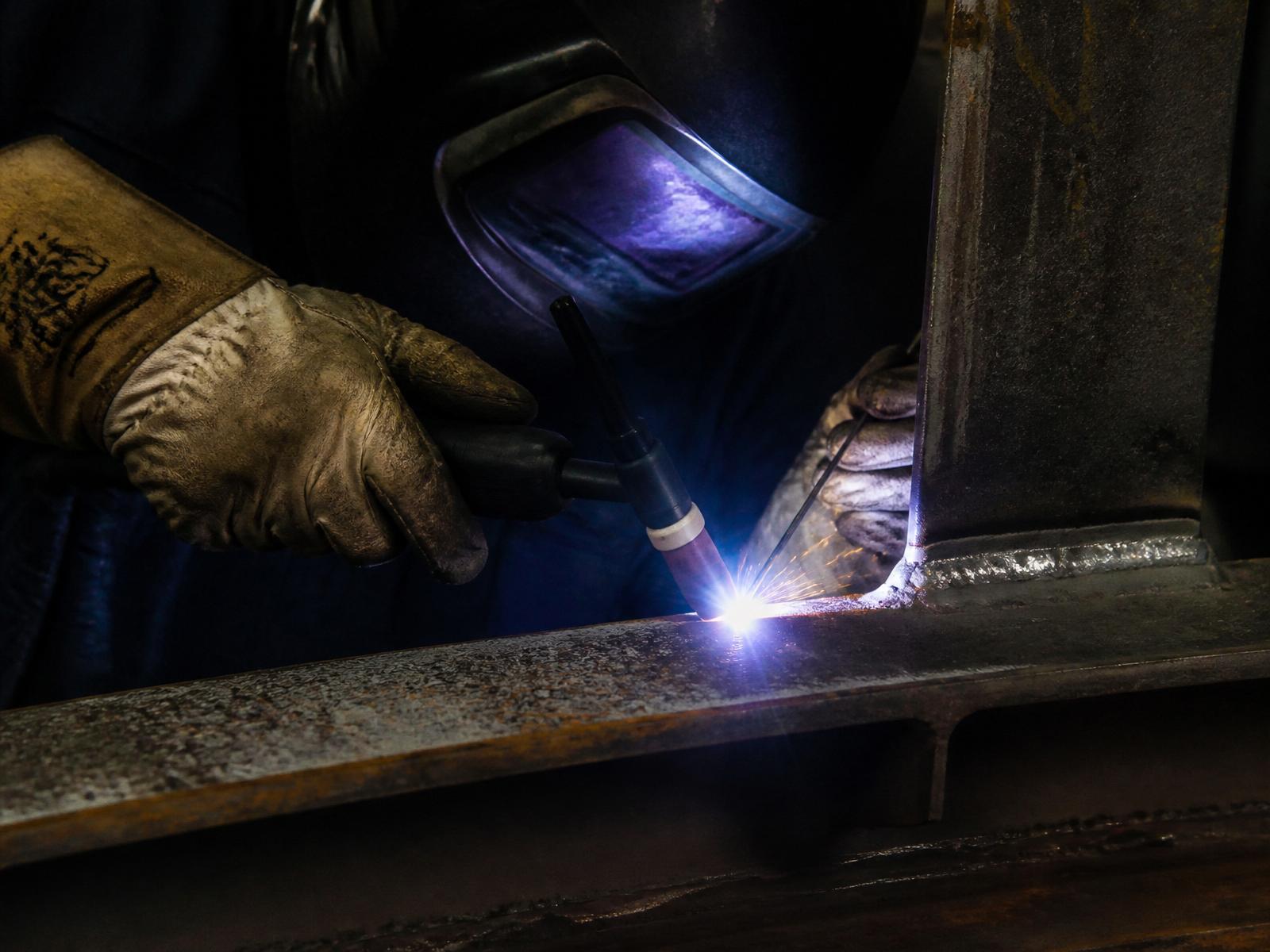 Certified welder repairing structural steel beam
